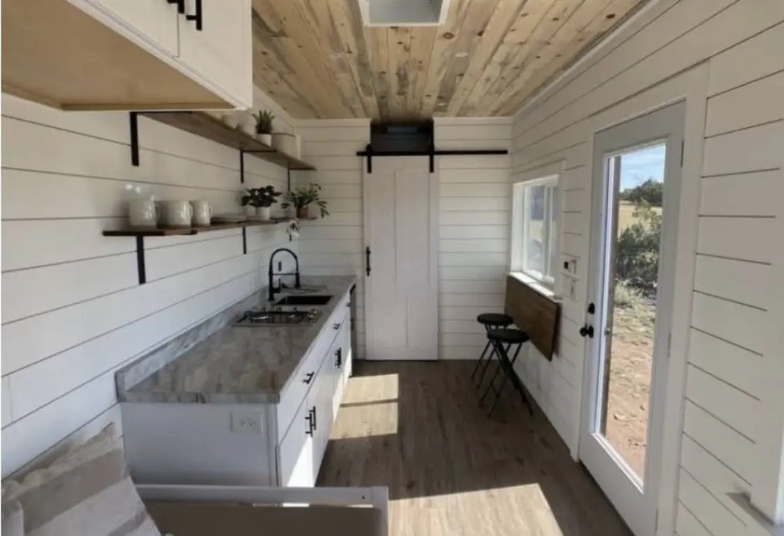 Tiny home kitchen with shiplap walls and barn door