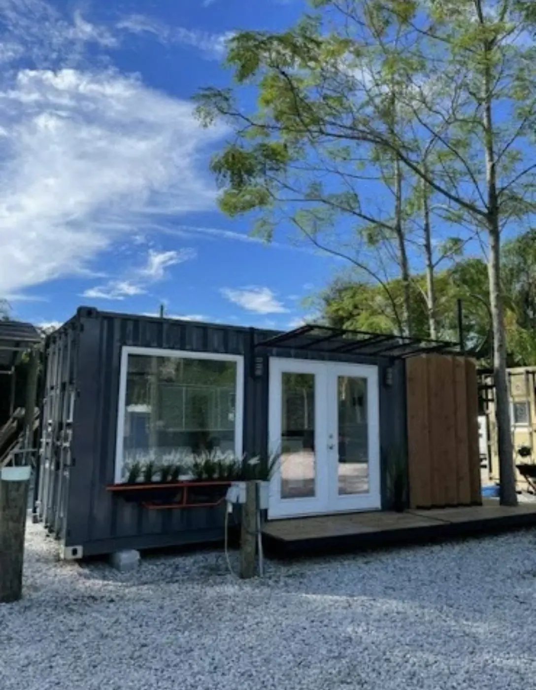 Custom shipping container tiny home with glass doors and pergola — The Foothills Tiny Home Company